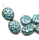 Two oval glass beads with a swirling blue and green pattern, shown on a white background with additional matching beads.