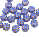 Blue czech glass beads with copper accents on a white background