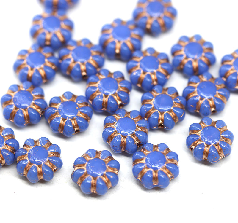 Blue czech glass beads with copper accents on a white background